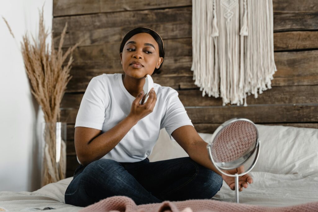 woman using a handheld beauty device at home