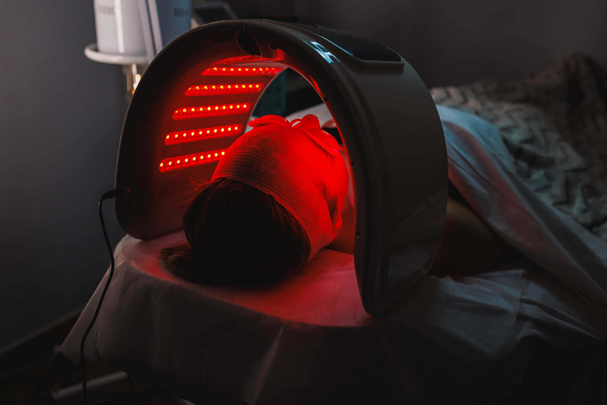 A person lying down for a red light hair growth treatment.