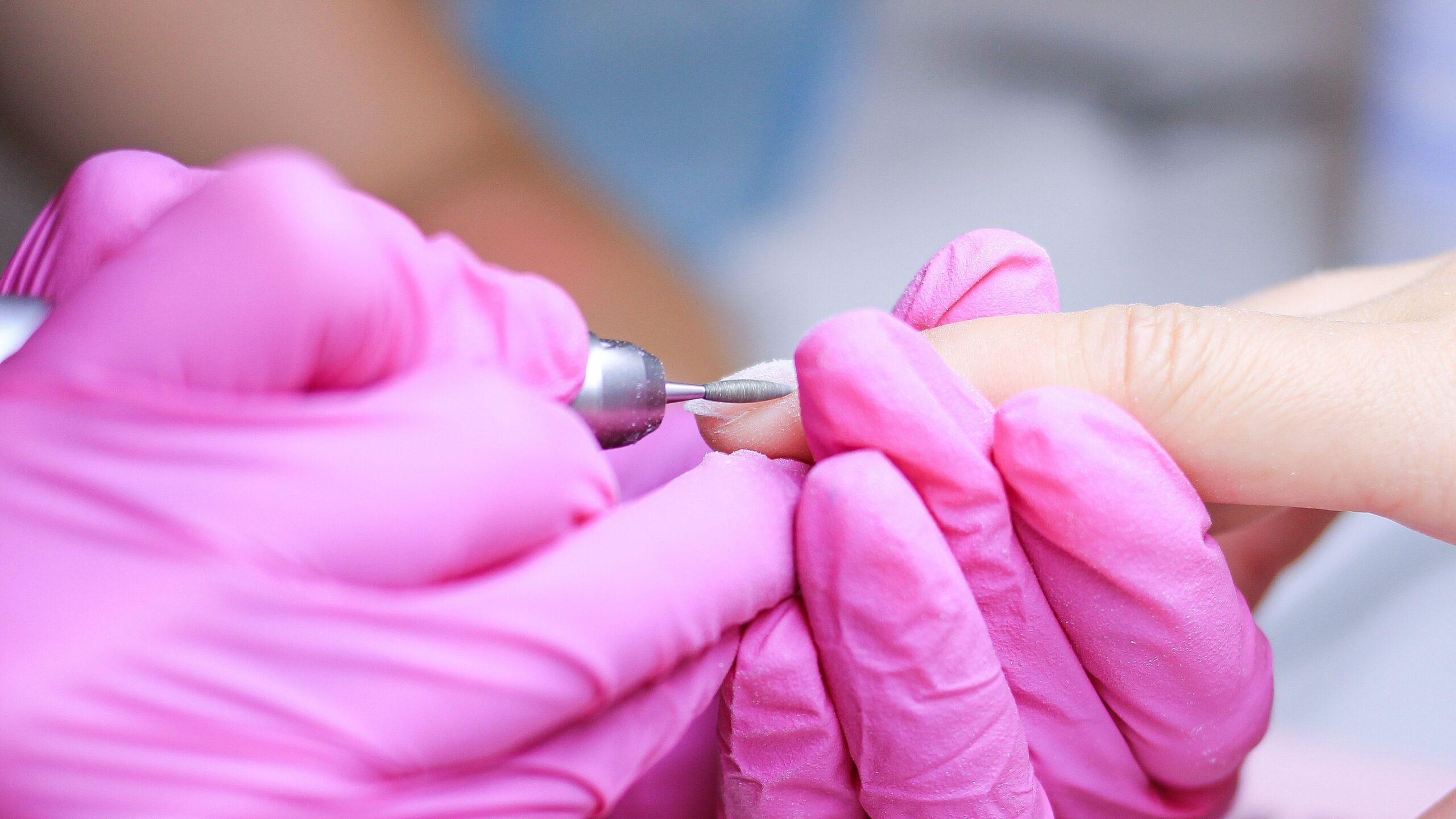 a professional doing nail gel removal with electric nail files